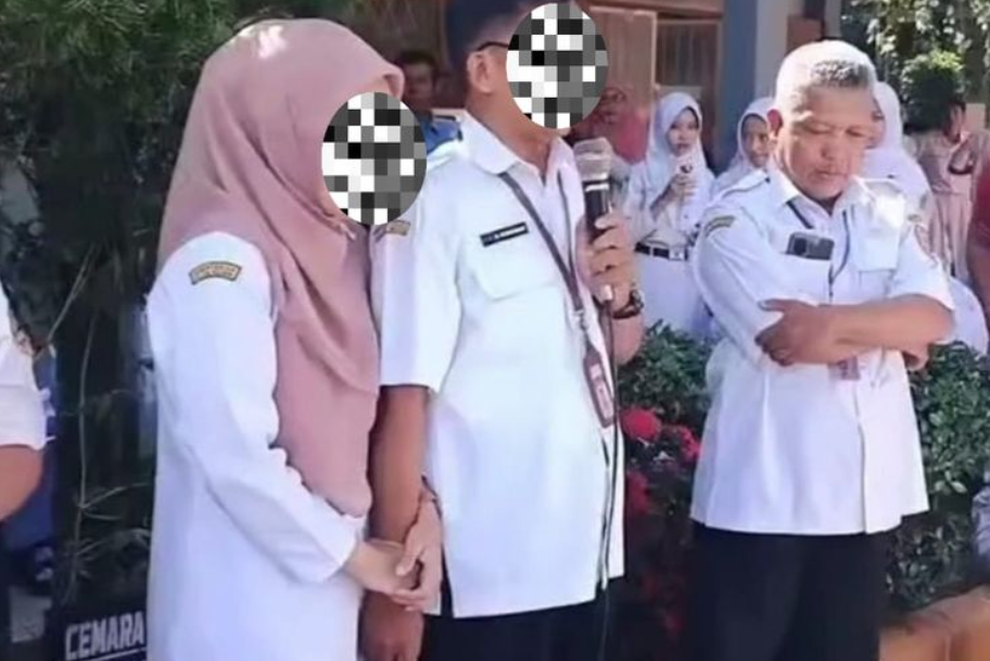 Sepasang guru SMAN 1 Bukateja, Purbalingga, bergandeng tangan saat menghadapi unjuk rasa siswa terkait kemelut SNBP, Rabu (5/2/2025). (KOMPAS.COM/Tangkapan Layar)