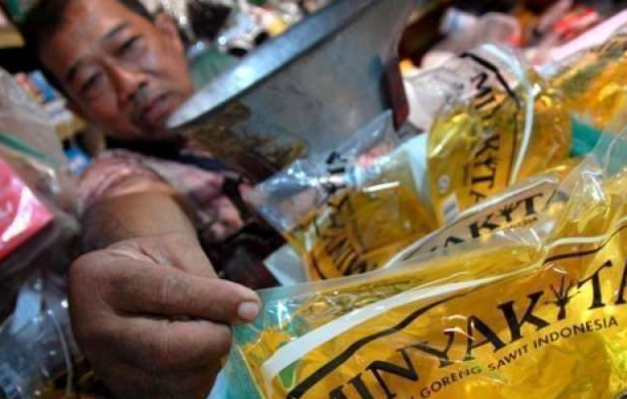 Seorang pedagang sedang memperlihatkan minyak goreng bersubsidi merek MinyaKita (Foto: Dokumentasi Antara/Eric Ireng)