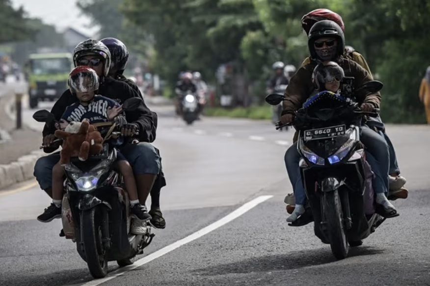 Pemudik bersepeda motor membawa anaknya melintas ke arah Cirebon dan Jawa Tengah di Jalan Raya Pantura, Indramayu, Jawa Barat(ANTARA FOTO/Fauzan/nym.)