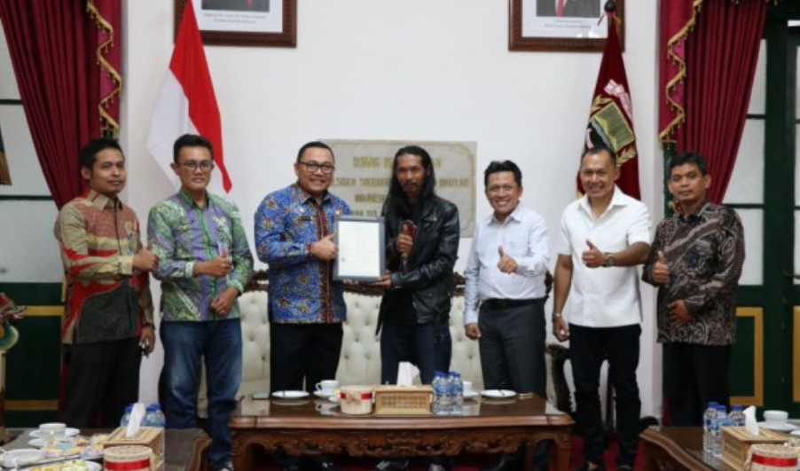 Kepala Kemenkum Jateng Heni Susila Wardoyo menyerahkan sertifikat hak cipta kepada seniman patung biawak, Arianto. (IDN Times/Fariz Fardianto)
