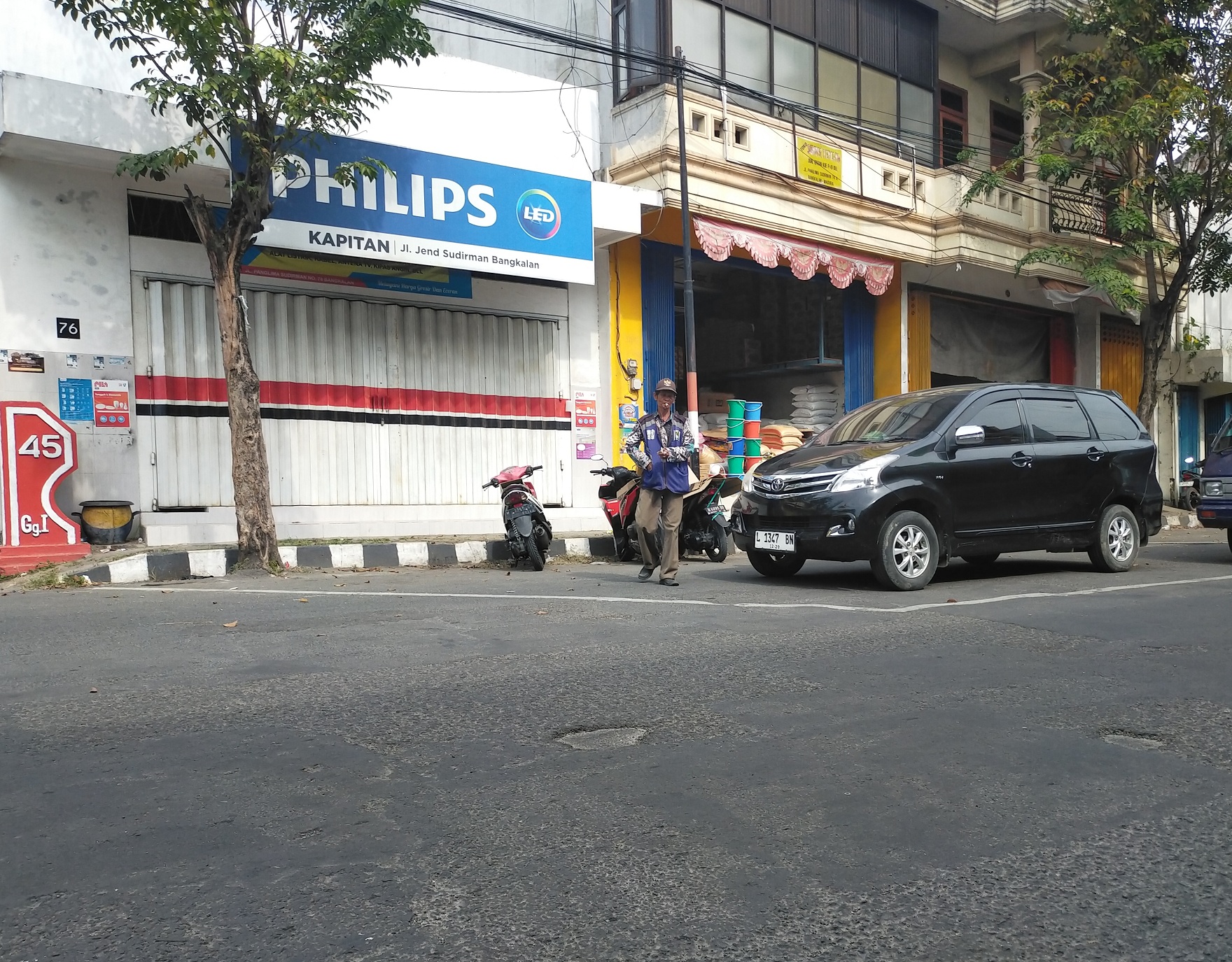 BERTUGAS: Jukir di Jalan Panglima Sudirman sedang mengawal kendaraan, Jumat (2/5). (VIVIN AGUSTIN HARTONO/JPRM)