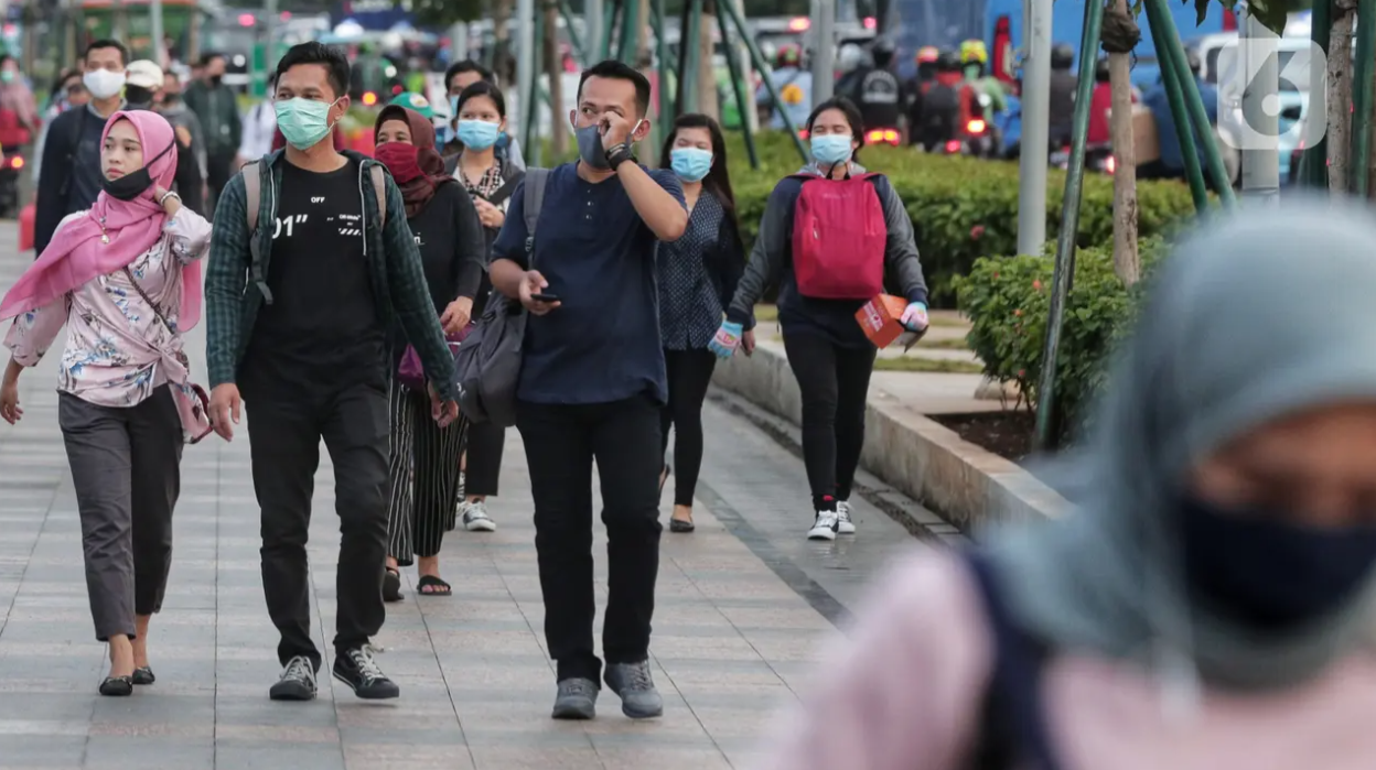 Sejumlah orang berjalan di trotoar pada saat jam pulang kantor di Kawasan Sudirman, Jakarta, Senin (8/6/2020). (Liputan6.com/Johan Tallo)