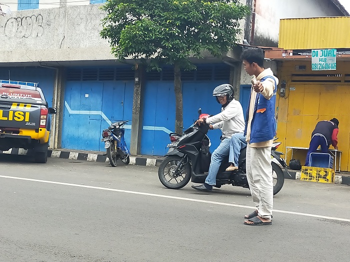 TAK TERTIB: Jukir tengah mengawal pengendara sepeda motor di Jalan Panglima Sudirman, Bangkalan, Selasa (27/5). (VIVIN AGUSTIN HARTONO/JPRM)