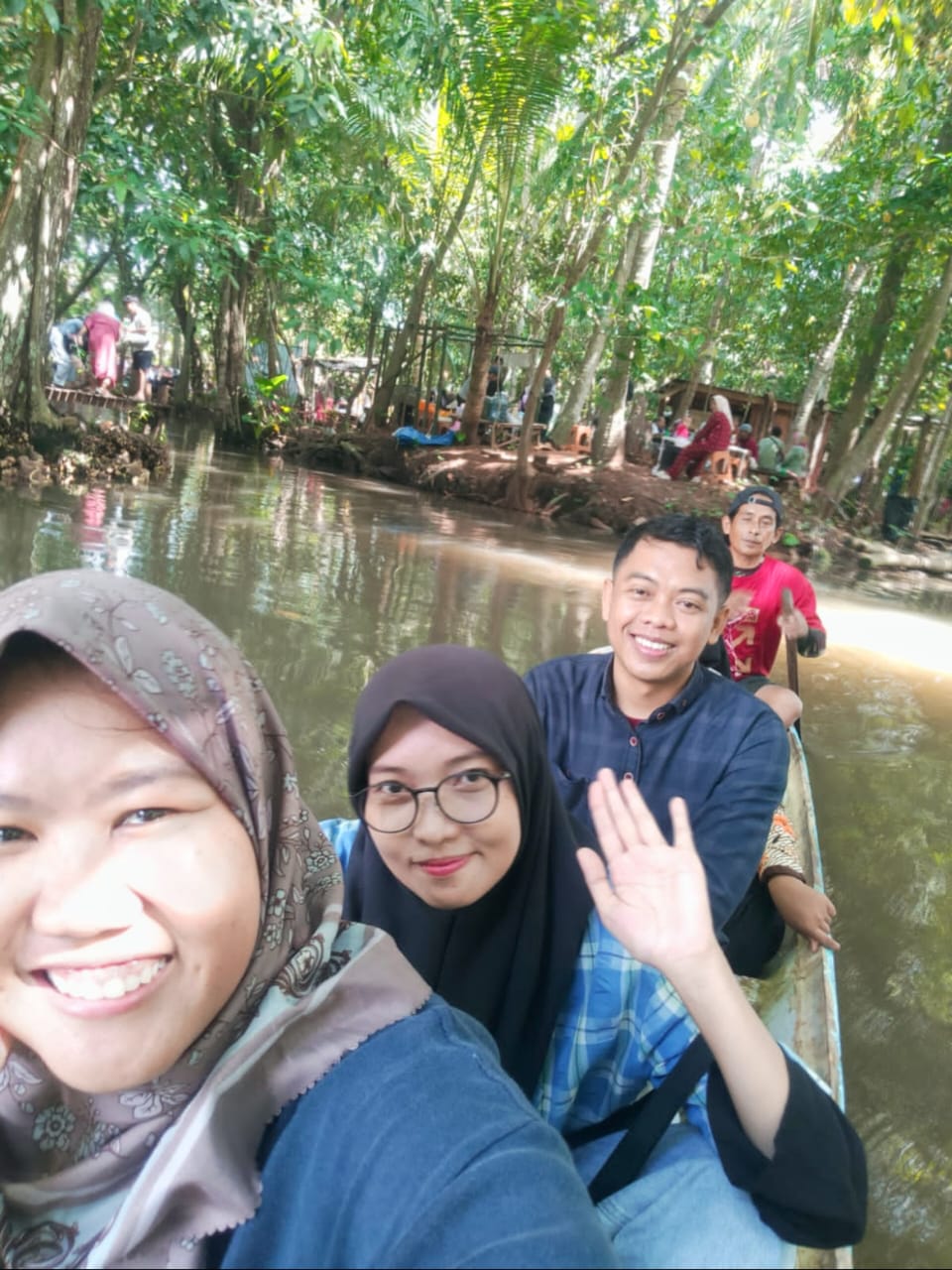 BERPERAHU: Pengunjung menyusuri Kali Saroka dengan menaiki perahu yang disediakan warga setempat. (SWAFOTO RADARBANGKALAN.ID)