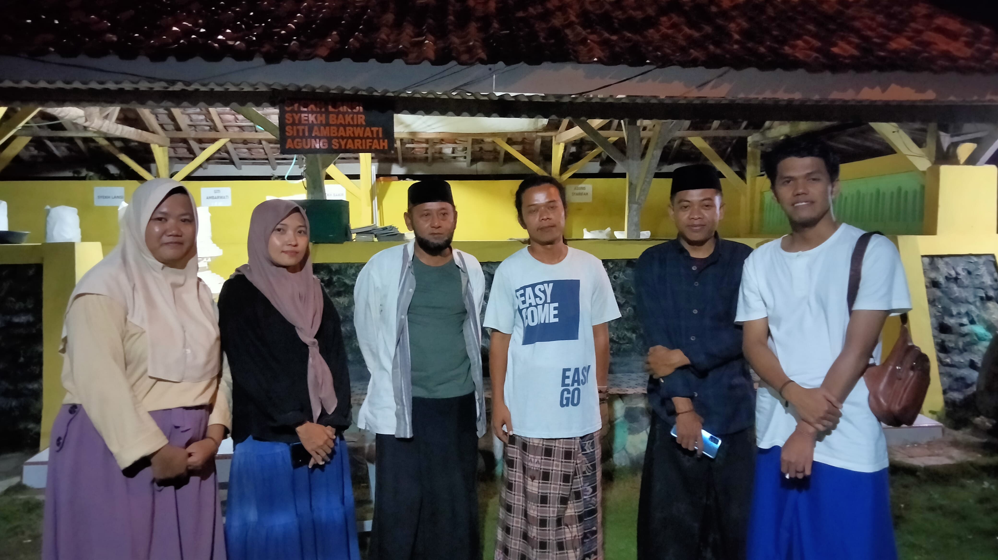 ZIARAH: Peziarah berfoto dengan musafir yang tinggal di lingkungan pesarean, Senin (2/6). (UMMUL HASANAH UNTUK RADARBANGKALAN.ID)