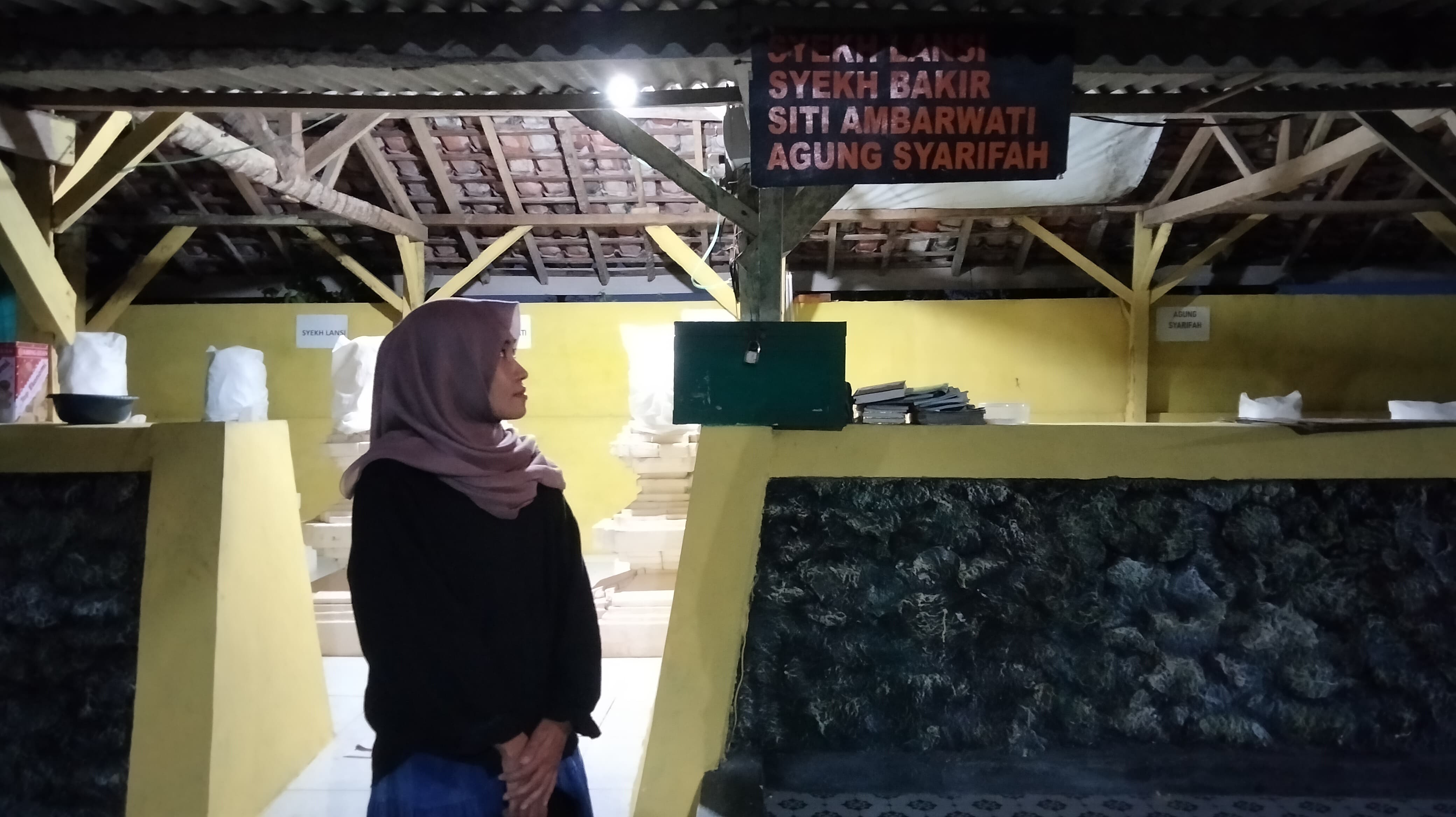 BUJUK PONGKENG: Peziarah mengabadikan momen di depan pintu masuk makam abdi Syekh Arif Muhammad bin Maulana Maghribi, Senin (2/6). (UMMUL HASANAH UNTUK RADARBANGKALAN.ID