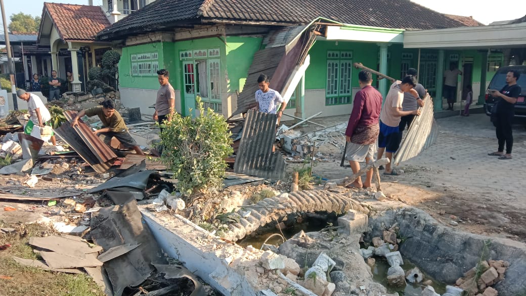 TINGGAL PUING PUING: Warga berada di rumah yang ditabrak mobil bermuatan rokok bodong, di Jalan Raya Burneh Bangkalan, Sabtu (7/6). (PJR SURAMADU UNTUK JPRM)