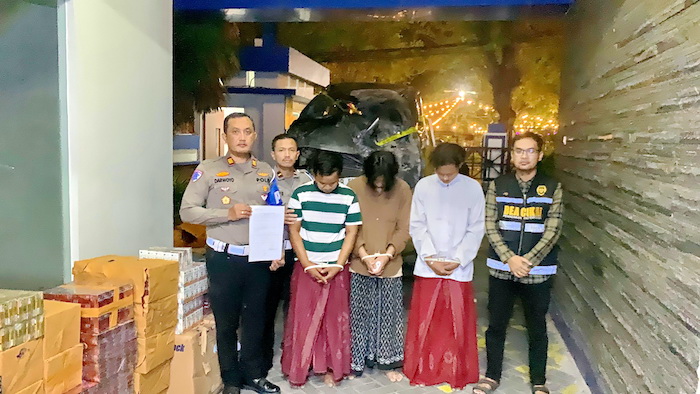 DIPROSES HUKUM: Kanit PJR VIII Suramadu Ditlantas Polda Jatim AKP Darwoyo menyerahkan tiga tersangka dan barang bukti rokok bodong ke Bea Cukai Madura, Sabtu (7/6). (PJR VIII SURAMADU UNTUK JPRM)
