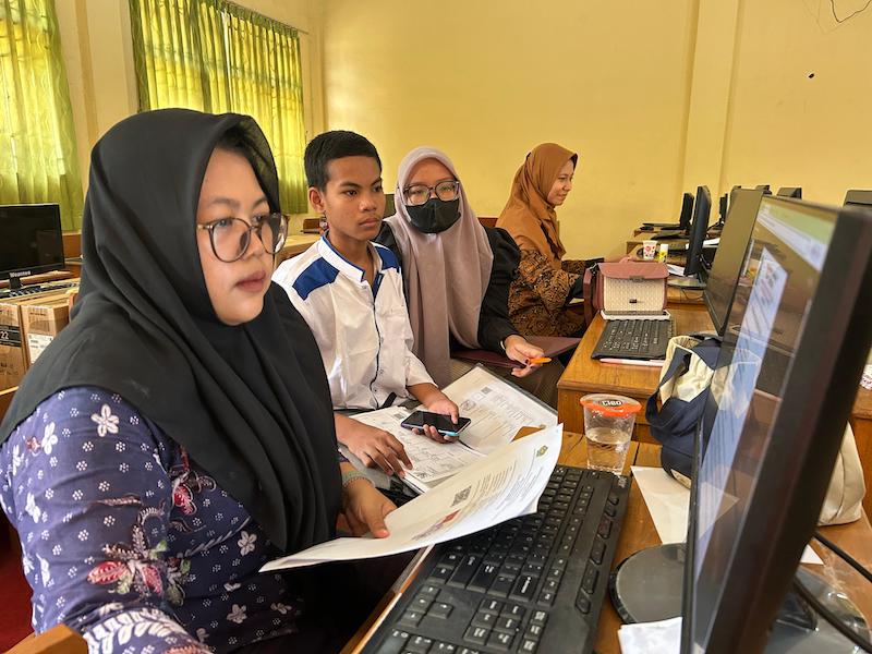 BERTUGAS: Operator SPMB SMAN 2 Bangkalan Laili Arofiyati melayani pengambilan PIN, Kamis (12/6). (VIVIN AGUSTIN HARTONO/JPRM)