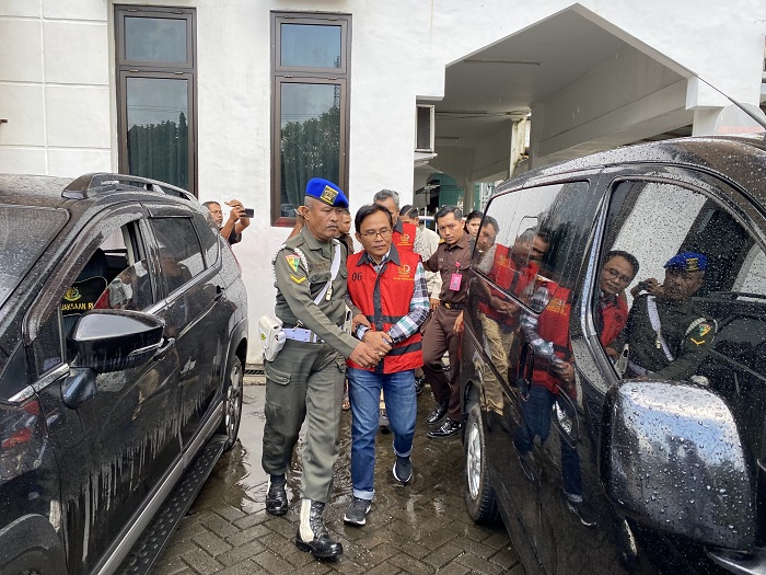 PENGHUNI RUTAN BARU: Komisaris PT TMM Sofiulloh Syarif (berkacamata) bersama dua tersangka lainnya digiring ke mobil tahan kejari, Senin (16/6). (JUPRI/JPRM)