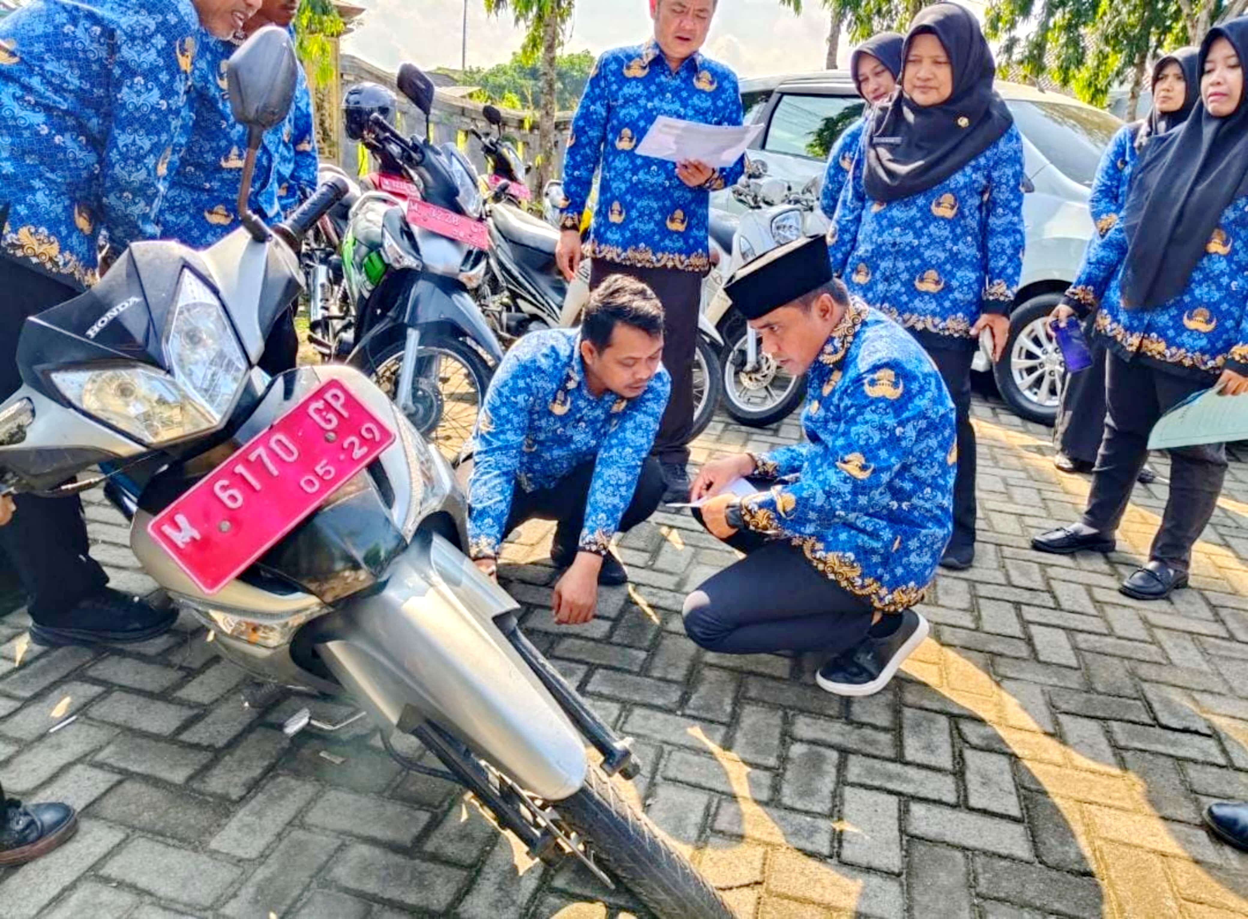 SERIUS: Bupati Bangkalan Lukman Hakim mengecek kondisi kendaraan roda dua aset milik daerah di kantor pemda, Selasa (17/6). (DISKOMINFO UNTUK JPRM)