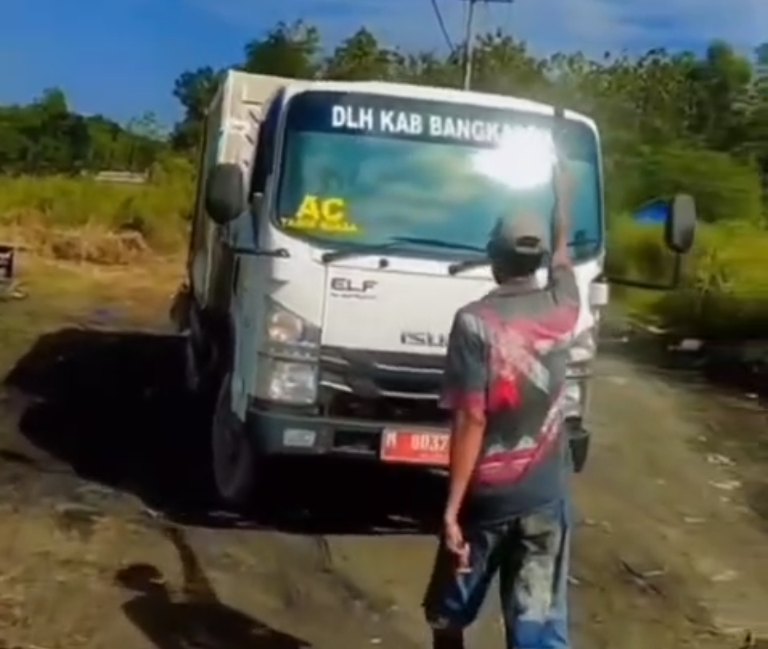 AKSI PENOLAKAN: Seorang warga mengacungkan senjata tajam (sajam) kepada sopir truk sampah di Desa Pacentan, Kecamatan Tanah Merah, Selasa (17/6).  &nbsp;