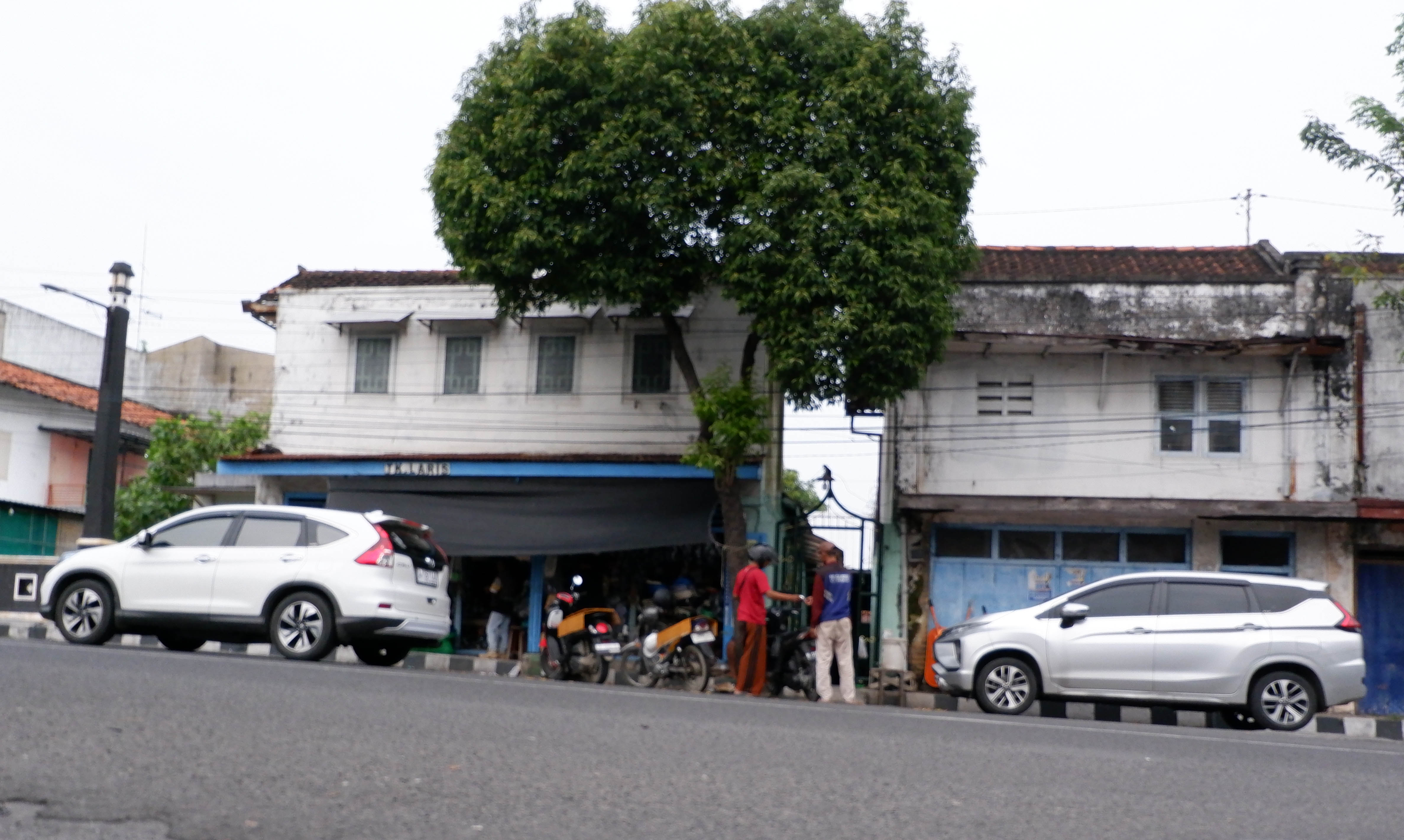 RAWAN DISALAHGUNAKAN: Seorang jukir sedang mengawal pengguna layanan jasa parkir di ruas Jalan Panglima Sudirman, Bangkalan, Kamis (19/6). (VIVIN AGUSTIN HARTONO/JPRM)
