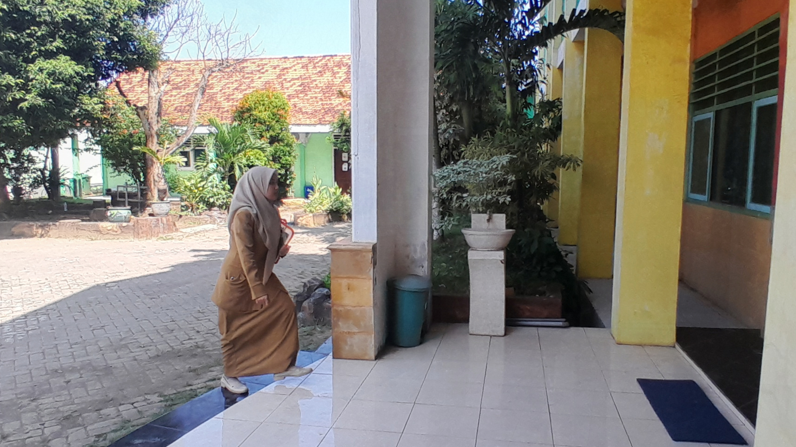 PAHLAWAN TANPA TANDA JASA: Guru SMPN 5 Bangkalan hendak memasuki ruang kelas Senin (23/6). (M. KHOLIL RAMLI/JPRM)