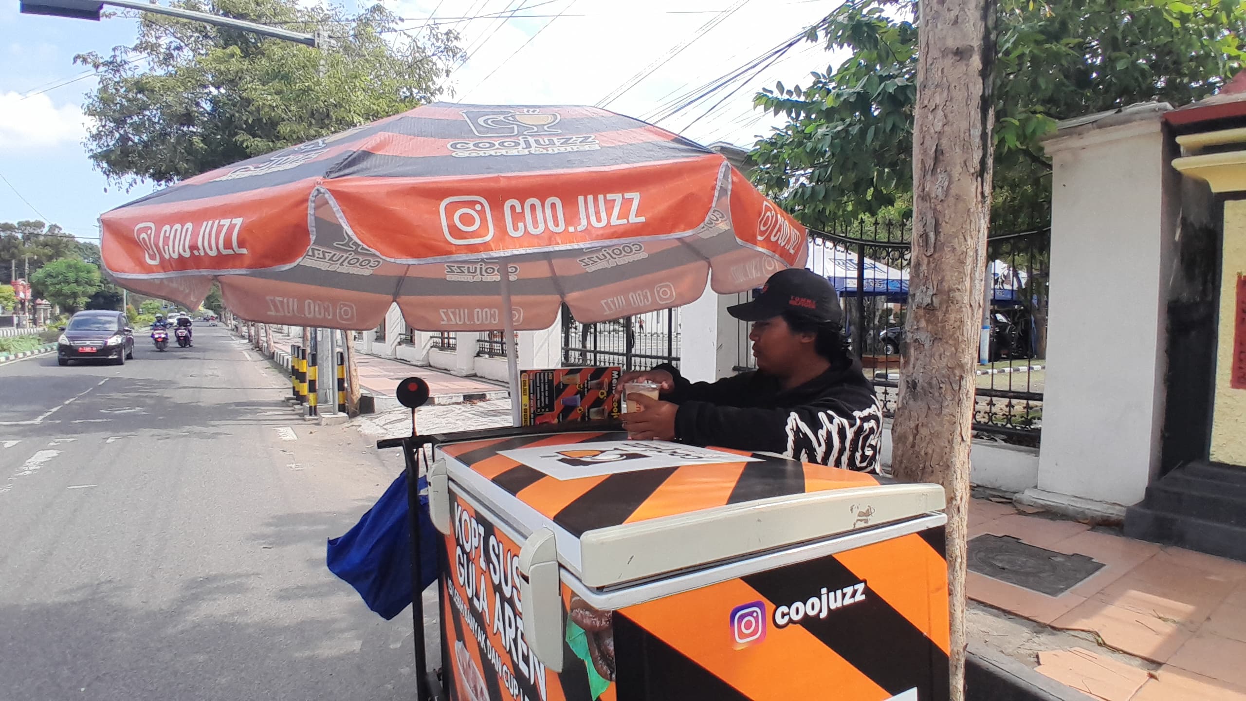 SEMANGAT KERJA: Dio, penjual kopi keliling, mangkal di Jalan Soekarno-Hatta, Bangkalan, Jumat (27/6). (KHOLIL RAMLI/JPRM)