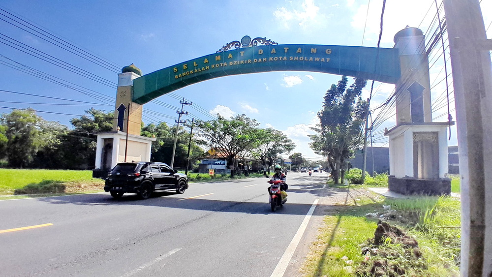 IKON: Kendaraan bermotor melintas di gerbang utama menuju Kota Bangkalan di Jalan Raya Burneh kemarin