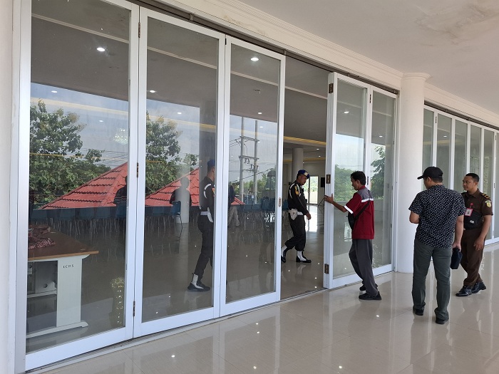 DIJAGA KETAT: Petugas berjalan di pintu masuk tempat pemeriksaan Kades yang dilakukan Kejati Jatim terkait program BSPS di Gedung Islamic Center Bindara Saod, Rabu (21/5). (MOH. IQBAL/JPRM)