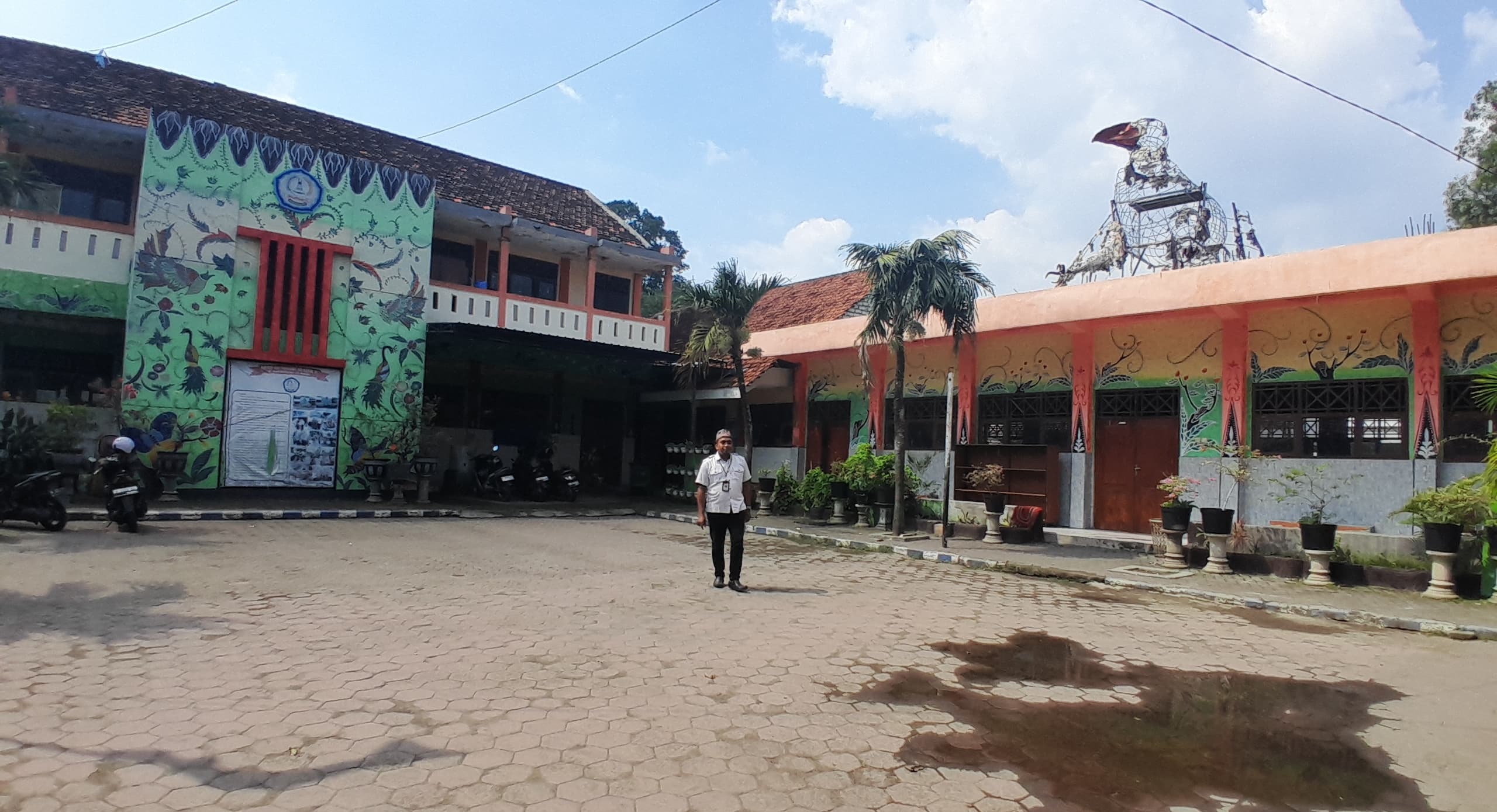 SASARAN REVITALISASI DISPENDIK: Guru SDN Mlajah 2, Bangkalan, berada di halaman sekolahnya, Rabu (2/7). (KHOLIL RAMLI/JPRM)