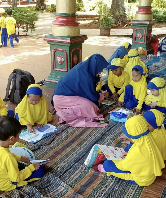 GIAT LITERASI: Guru TK bersama murid-murid sedang membaca buku bersama di Taman Baca Paseban, Jumat (20/6).&nbsp;
