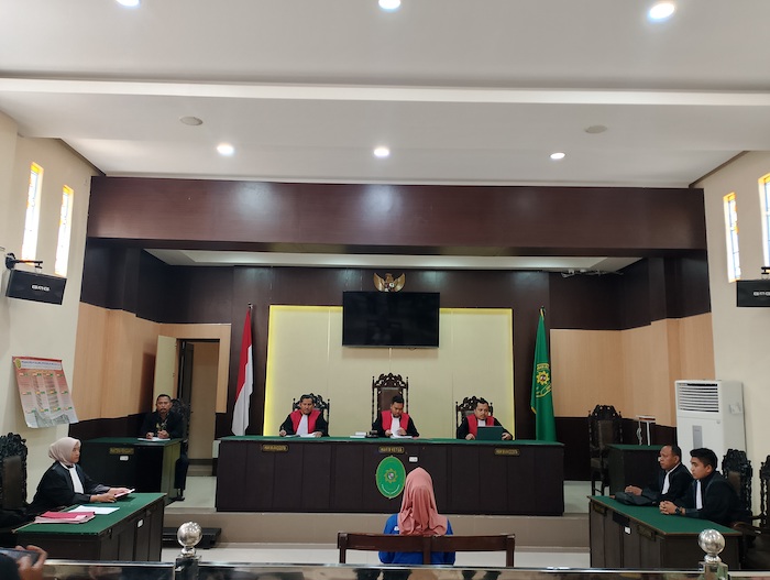 MENYIMAK DAKWAAN JPU: Terdakwa Syamsiyah mengikuti agenda sidang perdana di Pengadilan Negeri Sampang, Kamis (10/7).