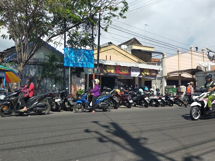 KONVENSIONAL: Juru parkir di Jalan KH Moh. Kholil Bangkalan tengah menjaga kendaraan, Jumat (4/7).