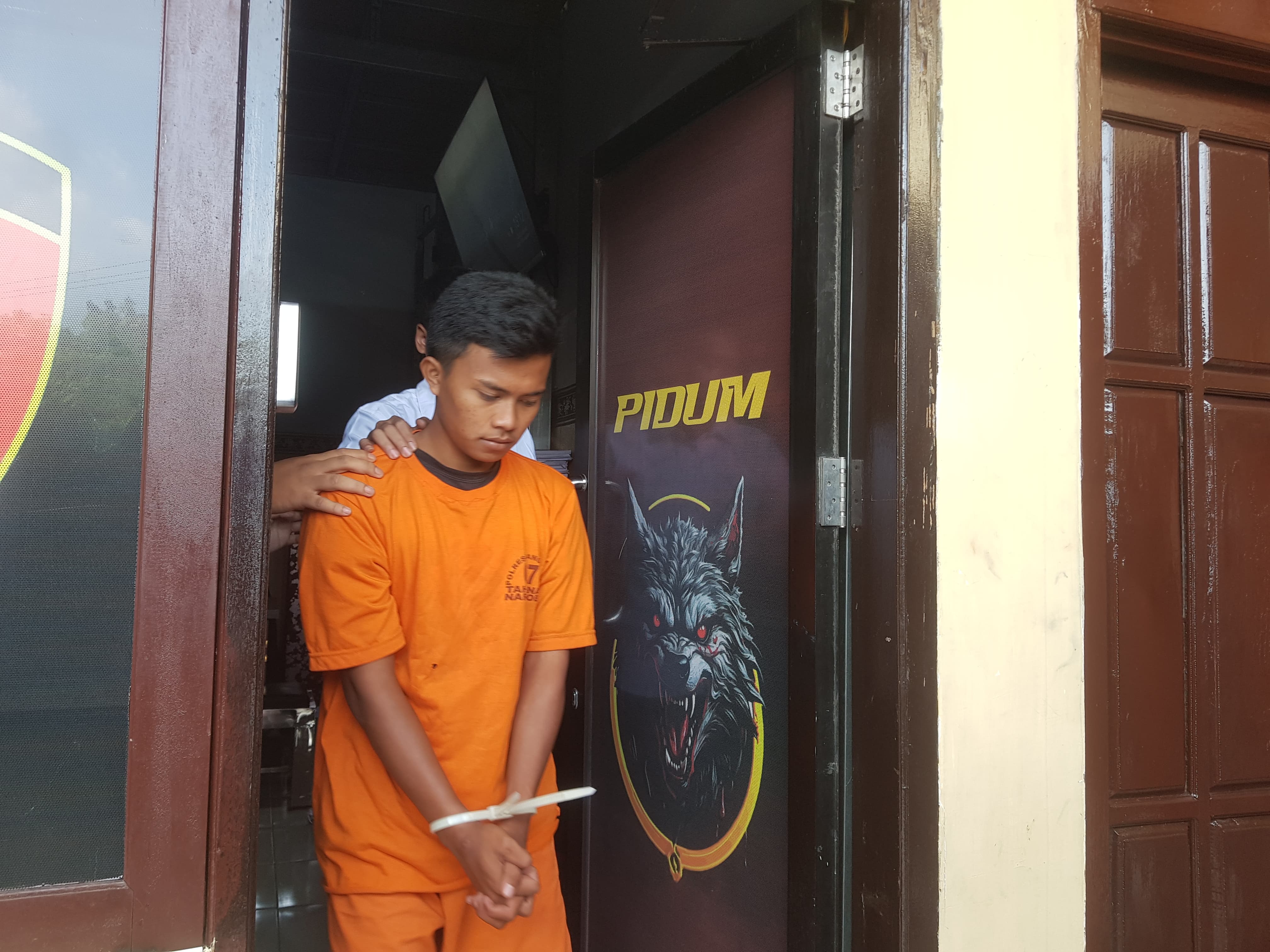 PASRAH: Aparat saat menggiring tersangka Rifqi Fauzan di Mapolres Bangkalan, Senin (23/6).