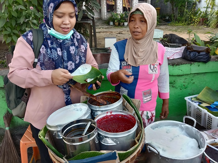 KHAS: Hadiyah Rahmawati (kiri) mencoba tajin sobih yang dijajakan penjual di Desa Burneh, Bangkalan, beberapa waktu lalu.