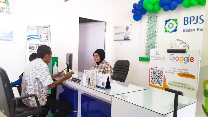PELAYANAN: Petugas BPJS Kesehatan melayani warga yang datang untuk berkonsultasi di kantor Jalan Halim Perdanakusuma Nomor 15 Bangkalan, Jumat (25/7).