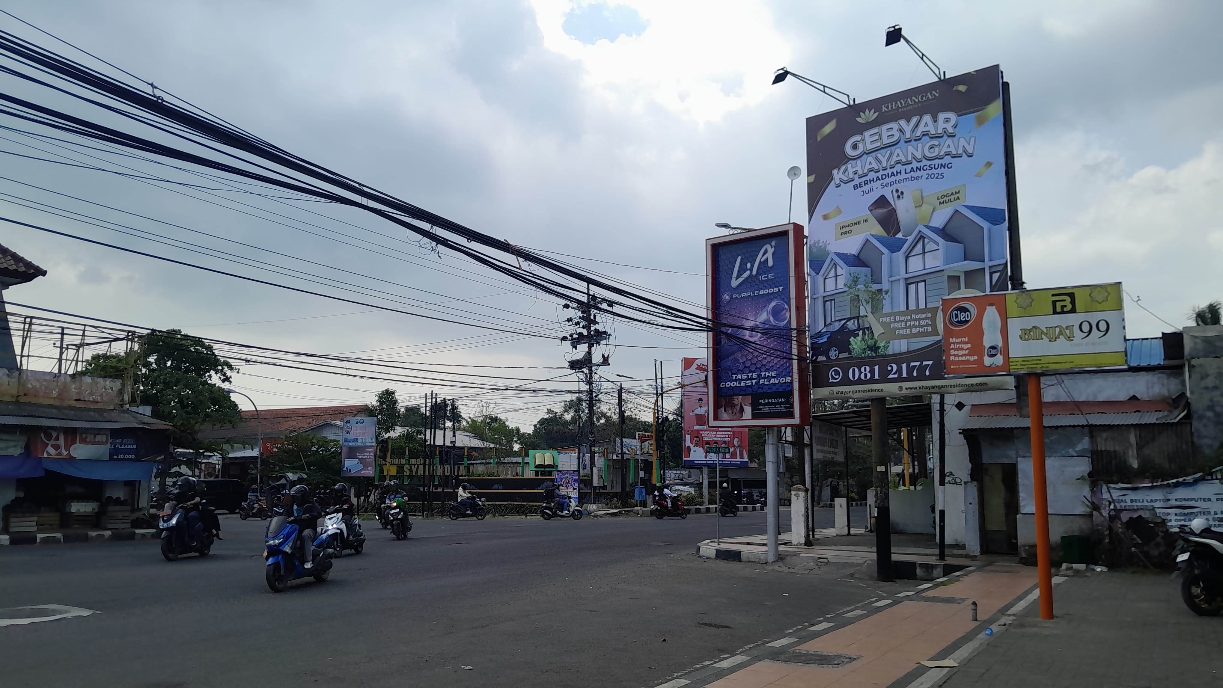 SUMBER PAD: Kendaraan bermotor melintas di sekitar reklame di simpang tiga Pasar Senenan, Bangkalan, Senin (28/7).