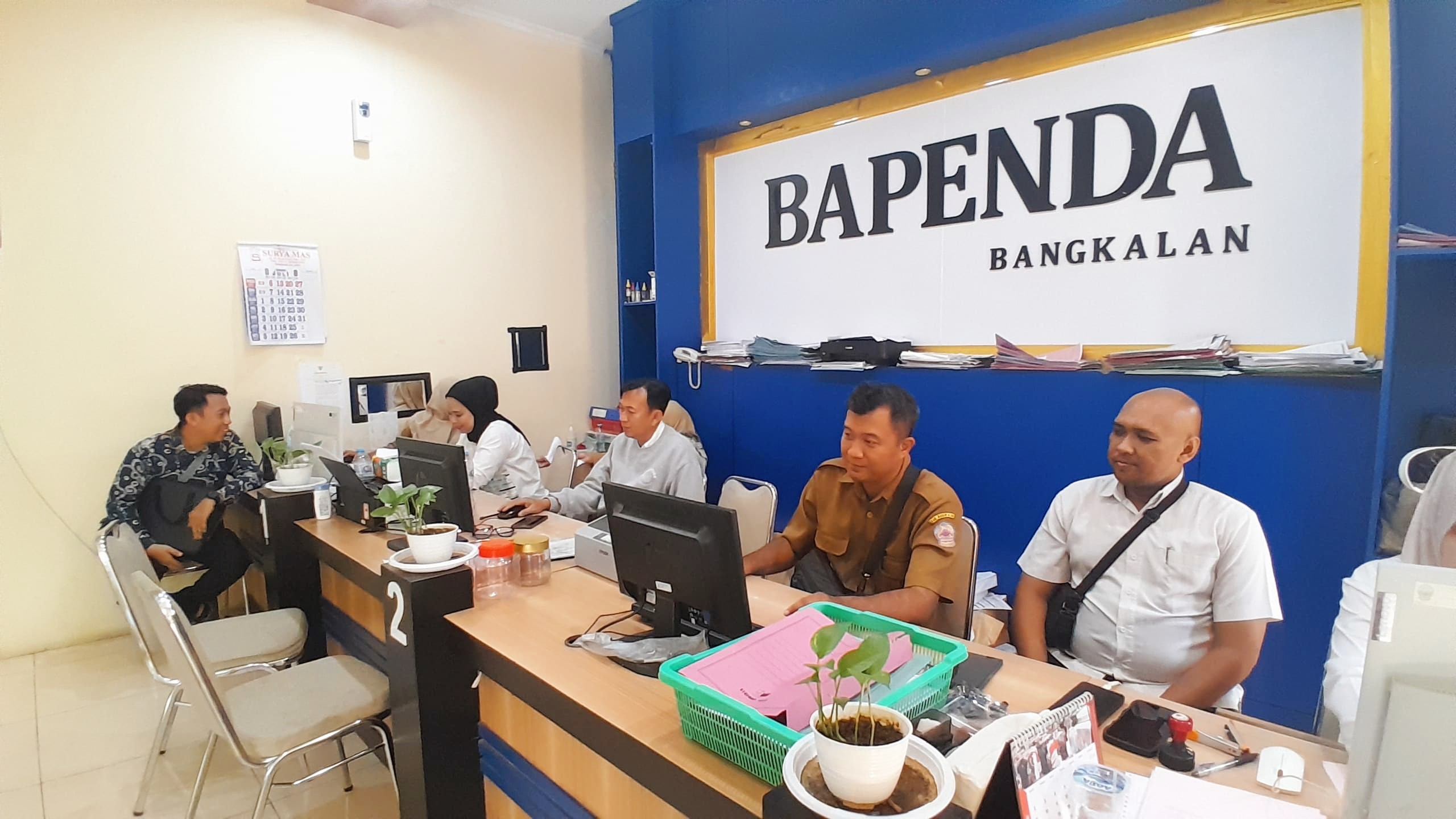 KONSULTASI: Petugas Bapenda Bangkalan sedang melayani warga tentang pajak, Selasa (21/7).&nbsp;