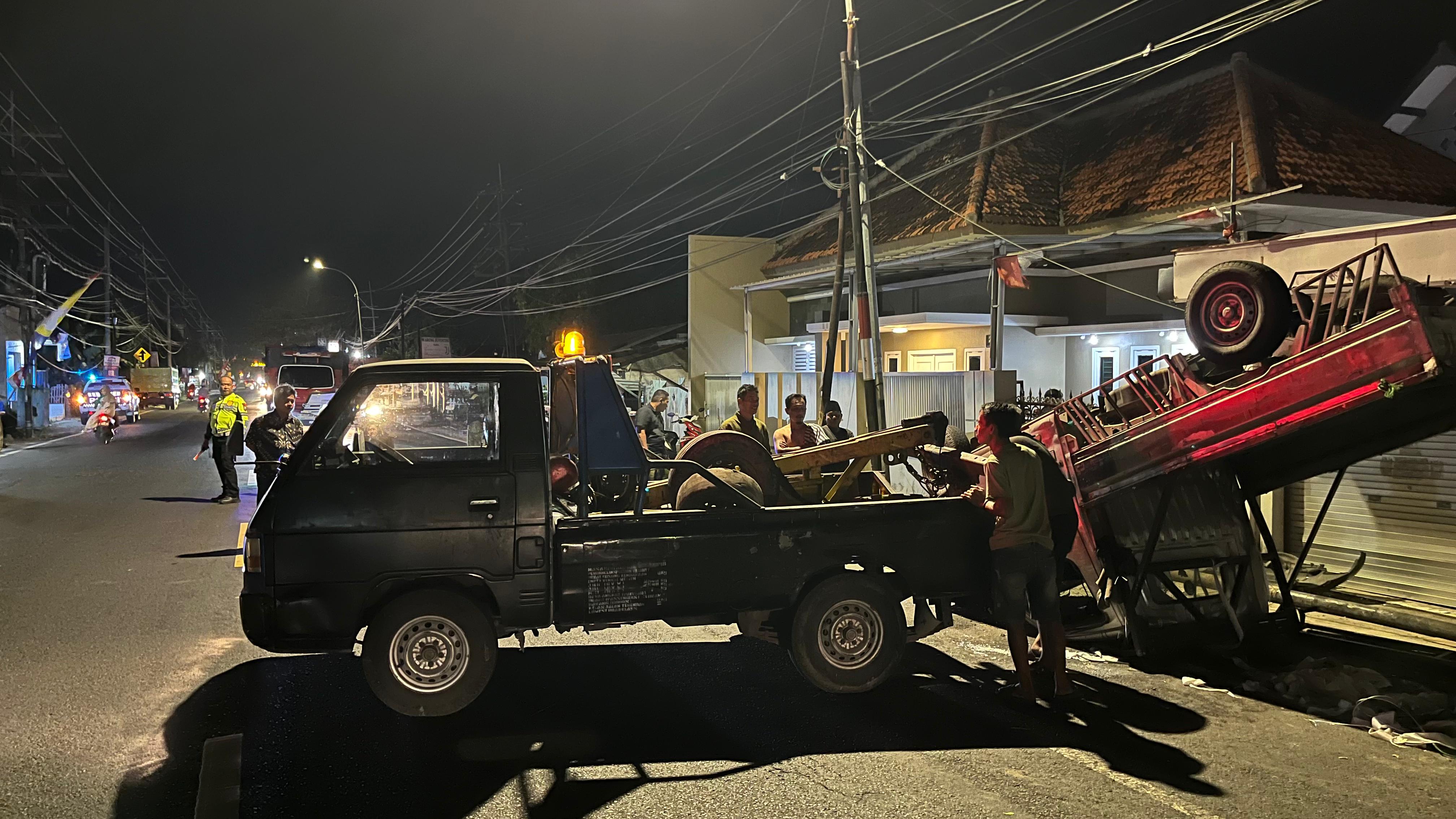 MENGANTUK: Petugas Satlantas Polres Bangkalan dibantu warga mengevakuasi pikap yang terlibat kecelakaan di Burneh, Bangkalan, Rabu (30/7) malam.&nbsp;