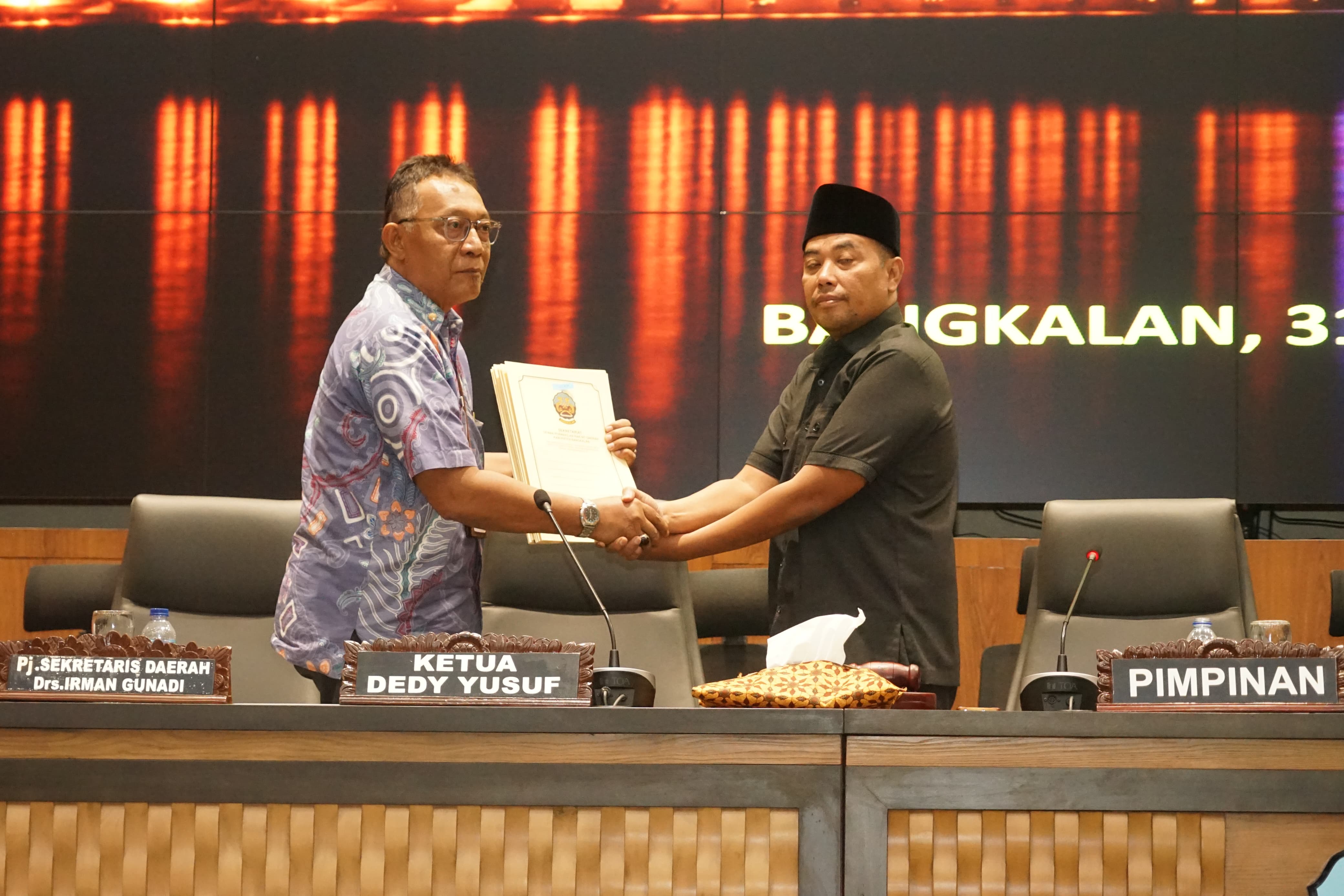 KOMITMEN: Wakil Ketua DPRD Bangkalan Efendi menyerahkan PU fraksi terhadap Raperda Perubahan ABPD 2025 kepada Pj Sekkab Irman Gunadi dalam rapat paripurna, Kamis (31/7).&nbsp;