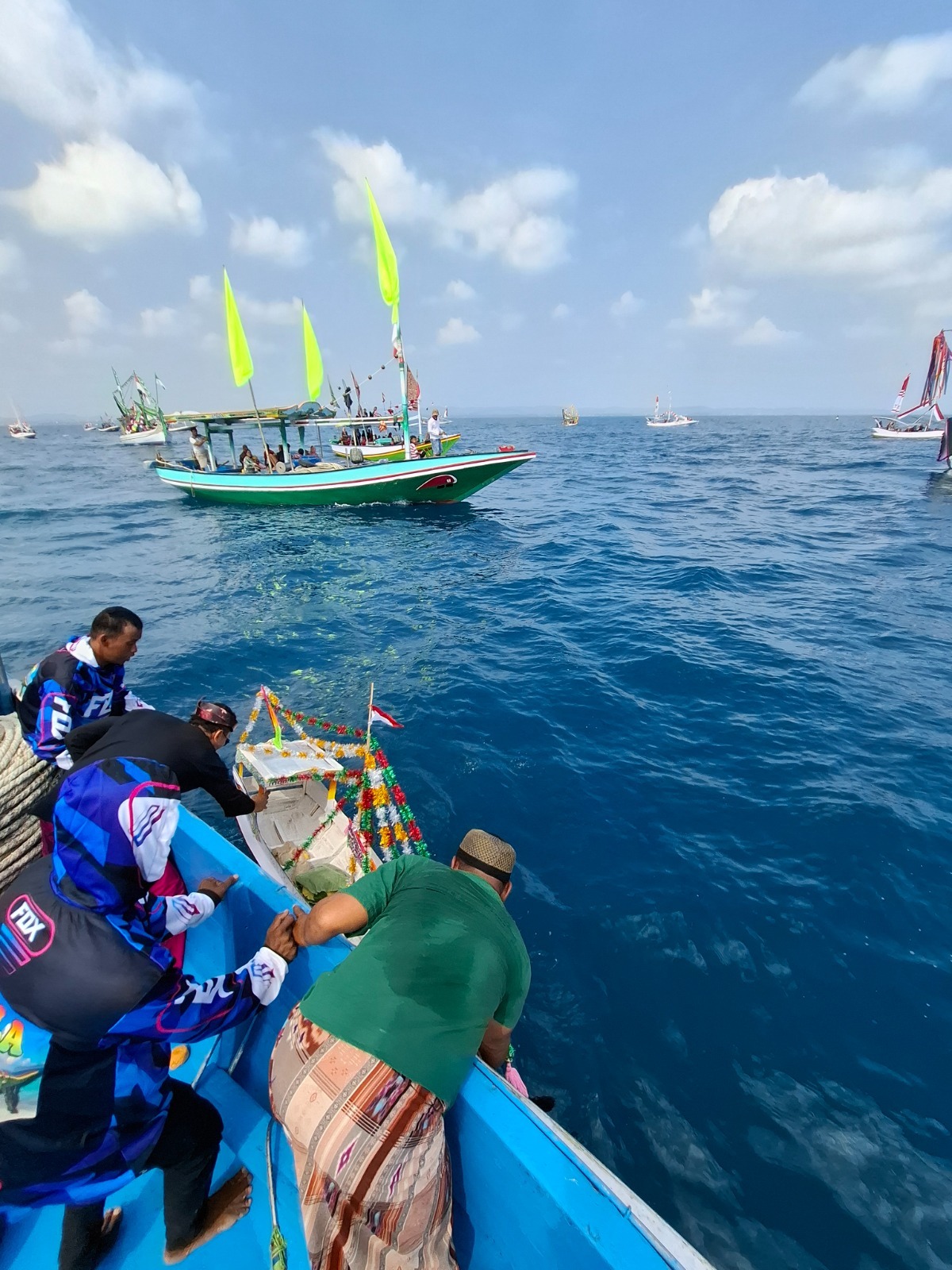 MERAWAT TRADISI: Warga Desa Banyusangka, Kecamatan Tanjungbumi, Bangkalan, melarungkan miniatur kapal berisi tumpeng sebagai bentuk sedekah laut pada acara rokat tase&rsquo;, Minggu (27/7).&nbsp;