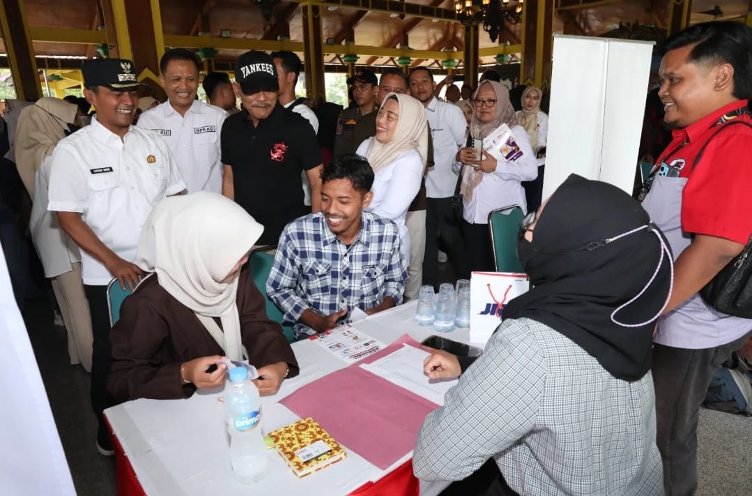 KOMUNIKATIF: Bupati Bangkalan Lukman Hakim melihat seorang pancaker di salah satu stan perusahaan saat job fair di Pendopo Pratanu kemarin.