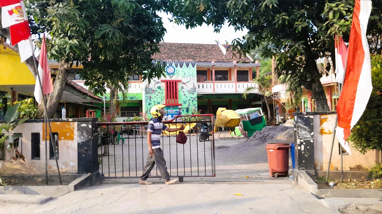 ASET PEMKAB: Pekerja sedang menutup pintu utama SD Negeri Mlajah 2, Bangkalan, Kamis (14/8).