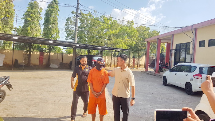 TAK BERKUTIK: Tersangka Asmad digiring aparat kepolisian di Mapolres Bangkalan Jumat (15/8).&nbsp;