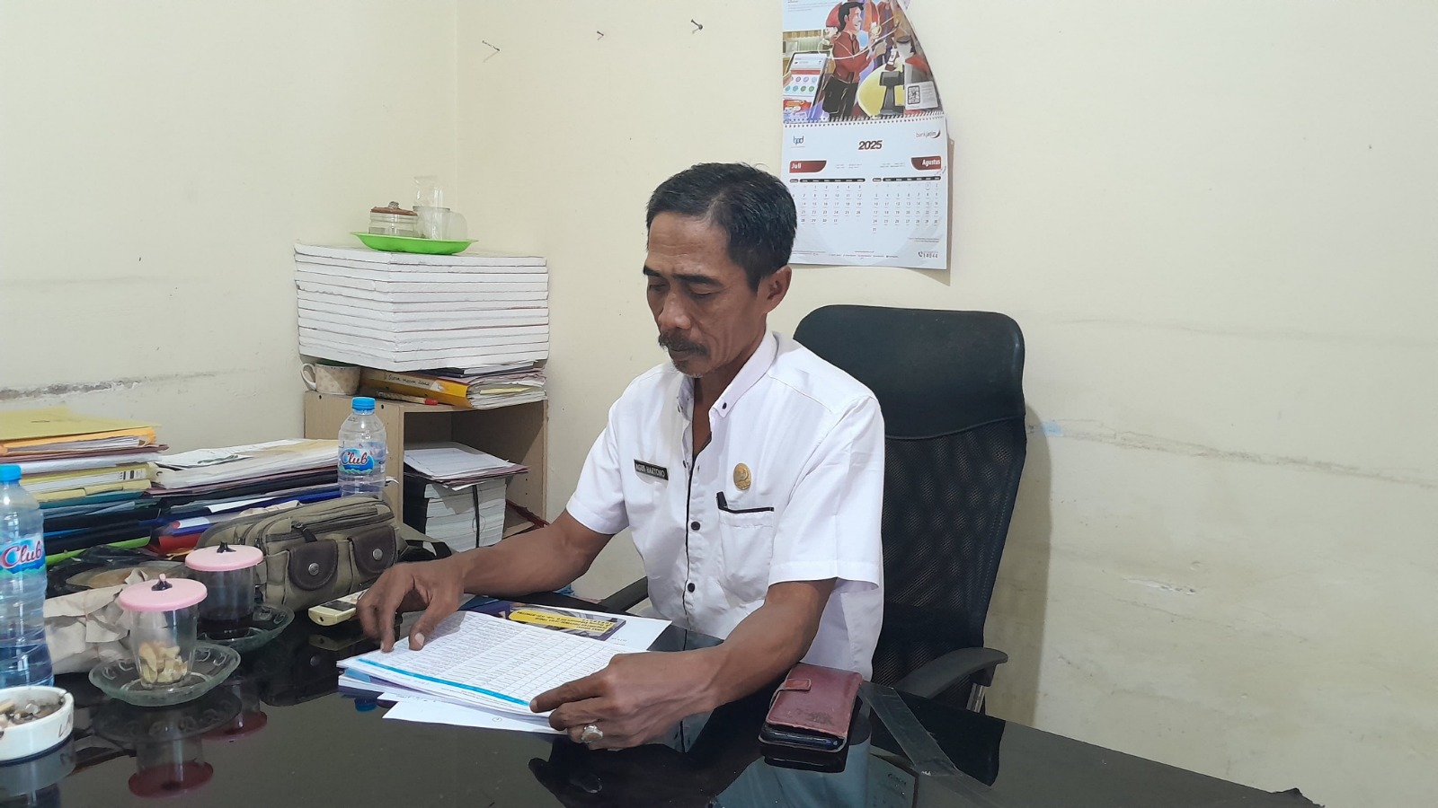 TELITI: Plt Kabid Rehabilitasi Sosial Dinsos Bangkalan Agus Haryono mengecek data KPM BLT penyandang disabilitas di kantornya, Kamis (21/8).&nbsp;