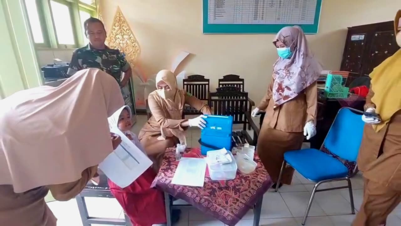 PENCEGAHAN: Petugas kesehatan melakukan imunisasi di SDN Babbalan, Kecamatan Batuan, Sumenep, Selasa (26/8).&nbsp;