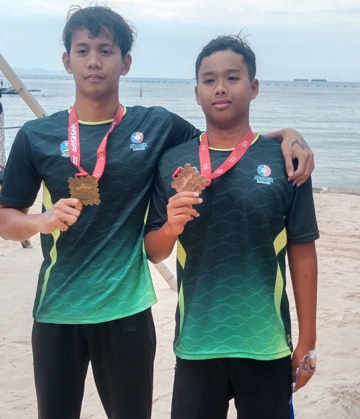 MEMBANGGAKAN: Atlet renang Bangkalan Satria Dwi Candra dan Moch. Akbar Putra Taufik berdiri di podium dalam Kejuaraan Nasional Akuatik OWS, Minggu (31/8).&nbsp;