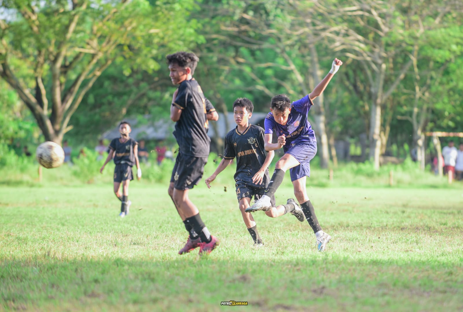 BERSAING: Pemain klub Putra Pahlawan menendang bola saat menghadapi Klub Mitra KSK dalam laga final Piala Soeratin tingkat kabupaten, Minggu (25/5).
