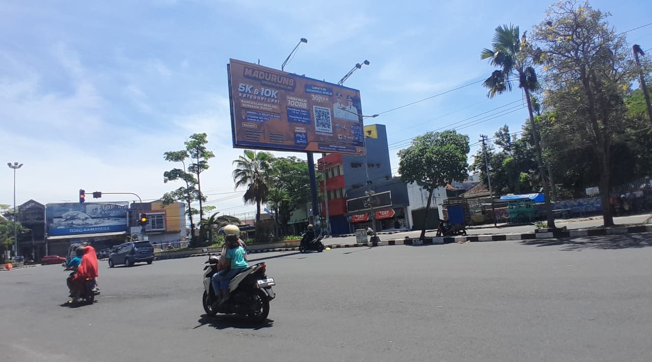SUMBER PAD: Pengendara melintas di dekat reklame yang berdiri di Jalan Jenderal A. Yani Bangkalan, Senin (15/9).&nbsp;