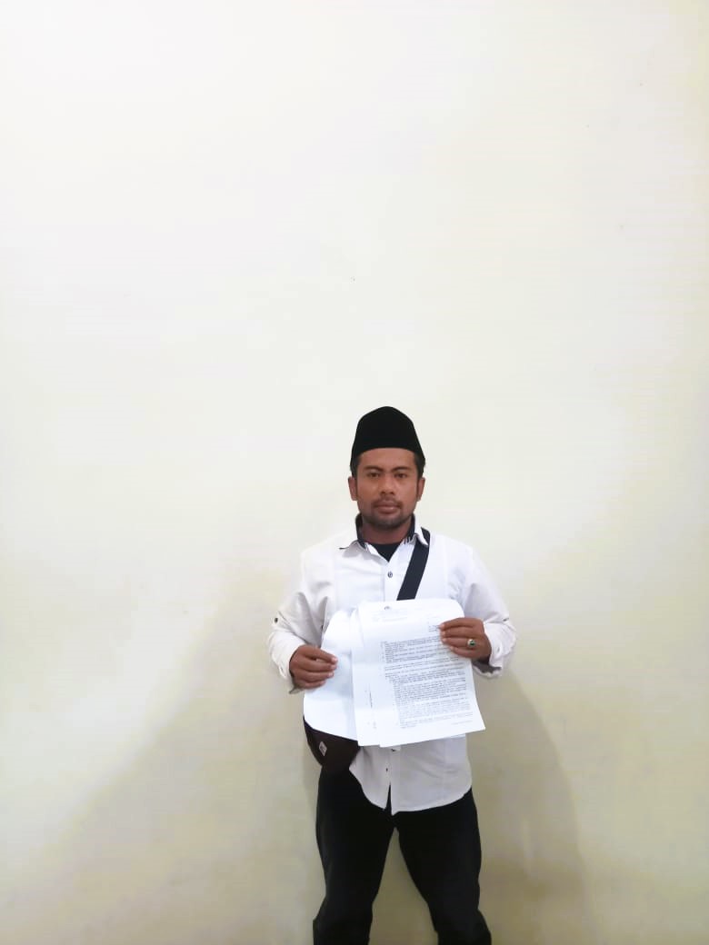 MENCARI KEADILAN: Pelapor Suherman menunjukkan surat laporan penganiayaan di rumahnya, di Desa Tenggun Dajah, Kecamatan Klampis, Selasa (30/9).