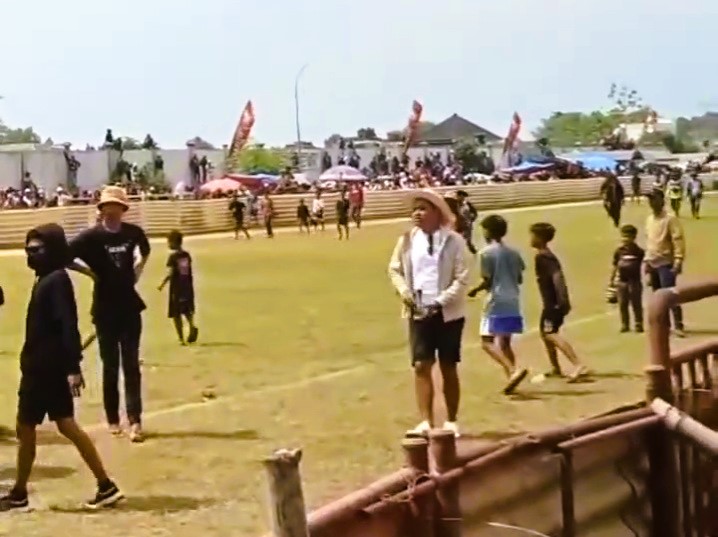 KERIBUTAN: Seorang pria diduga mengeluarkan senpi saat Karapan Sapi Piala Bupati Bangkalan 2025 di Skep RP Moch. Noer, Minggu (21/9).&nbsp;