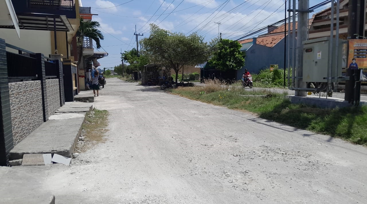JALAN RUSAK: Warga melintas di jalan utama menuju Perumahan Wisma Pangeranan Asri Bangkalan, Selasa (7/10).&nbsp;