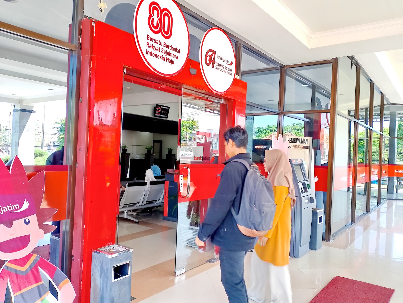 LAYANAN PUBLIK: Warga berada di halaman kantor Bank Jatim Cabang Sampang, Rabu (8/20).&nbsp;