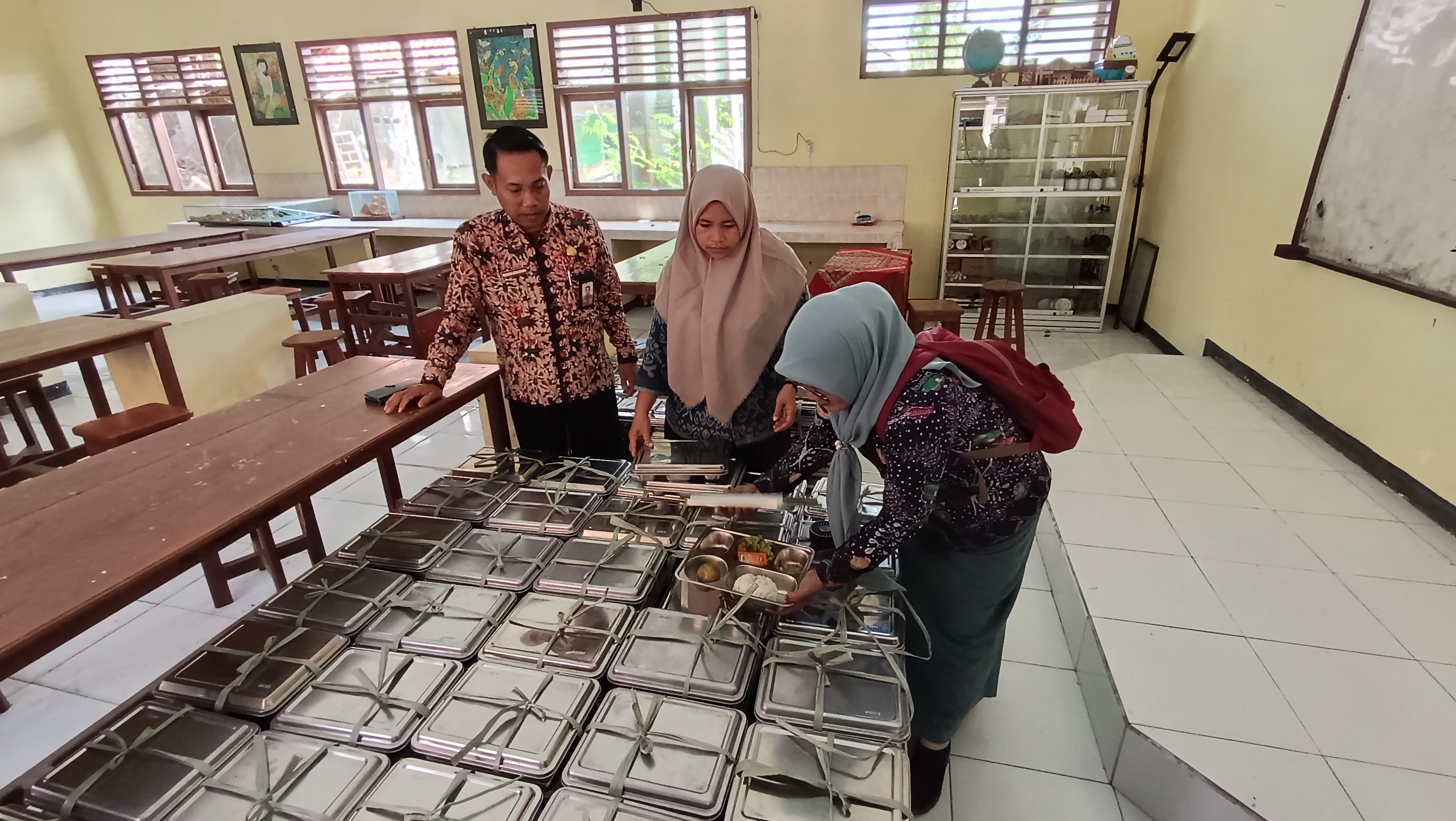 DIPASTIKAN AMAN: Guru SMAN 3 Bangkalan mengecek menu makan bergizi gratis (MBG) Senin (8/9).&nbsp;