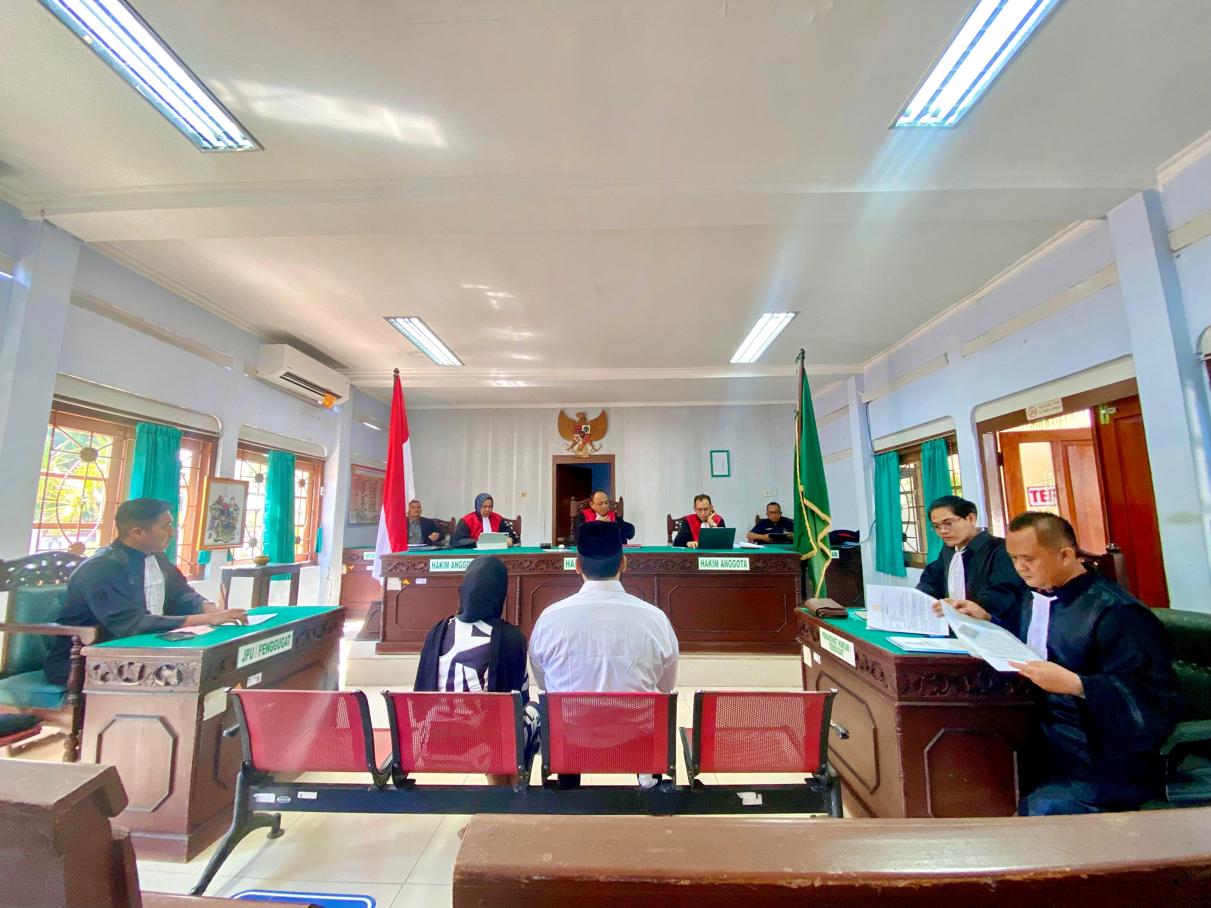 SIDANG PERDANA: Terdakwa Zainal Arifin dan Siti Kholisah duduk di bangku terdakwa Pengadilan Negeri Pamekasan, Kamis (15/10).&nbsp;