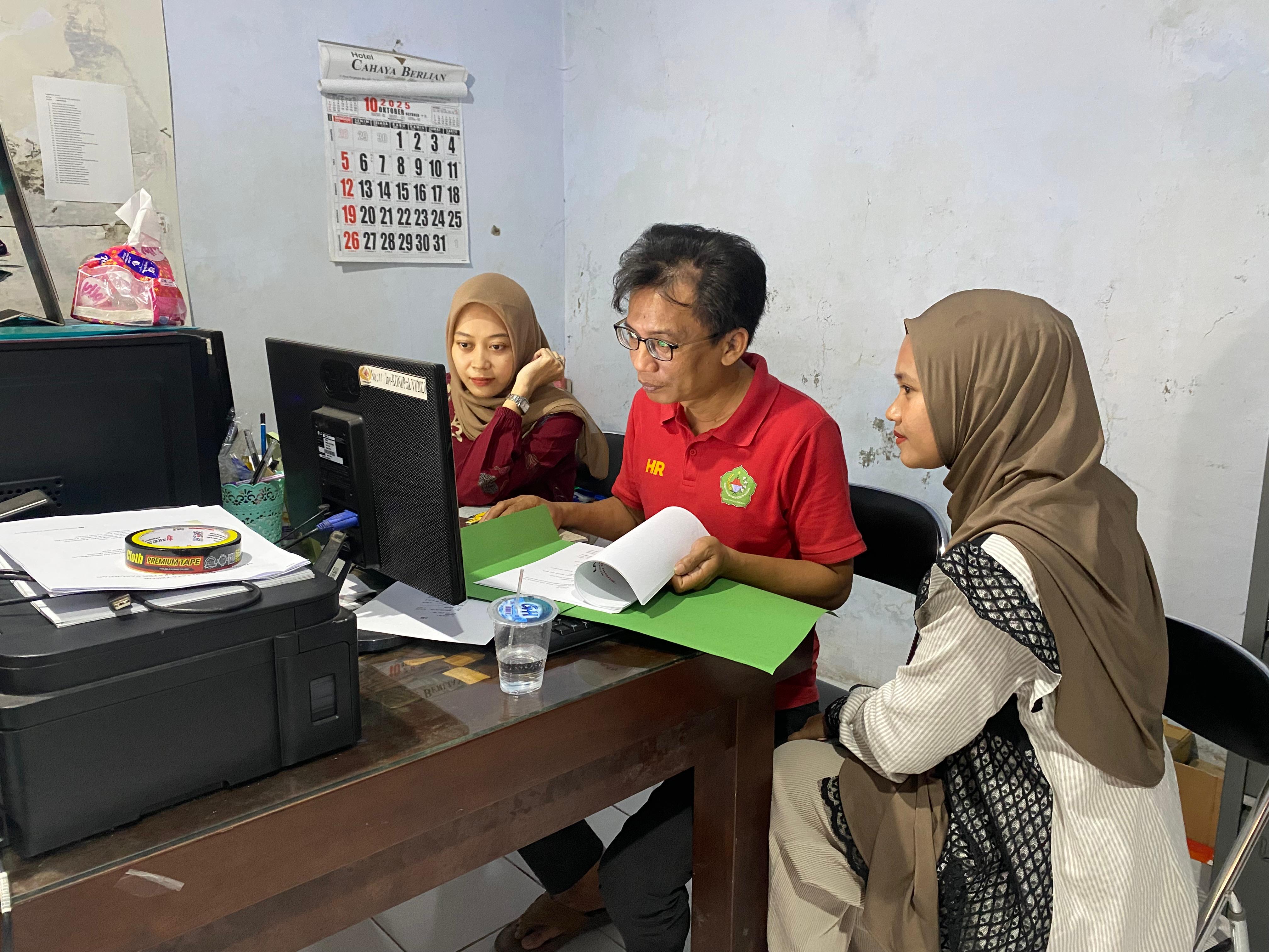 BERSIAP: Sekretaris KONI Pamekasan Heri Purwanto (tengah) menunjukkan rancangan musorkab kepada staf, Kamis (16/10).&nbsp;