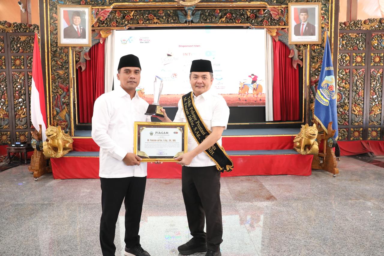 DIAPRESIASI: Bupati Bangkalan Lukman Hakim (kiri) menyerahkan piagam penghargaan tokoh pelopor prestasi olahraga kepada wakilnya, Moch. Fauzan Ja&rsquo;far (kanan), di Pendopo Agung, Rabu (24/9).&nbsp;