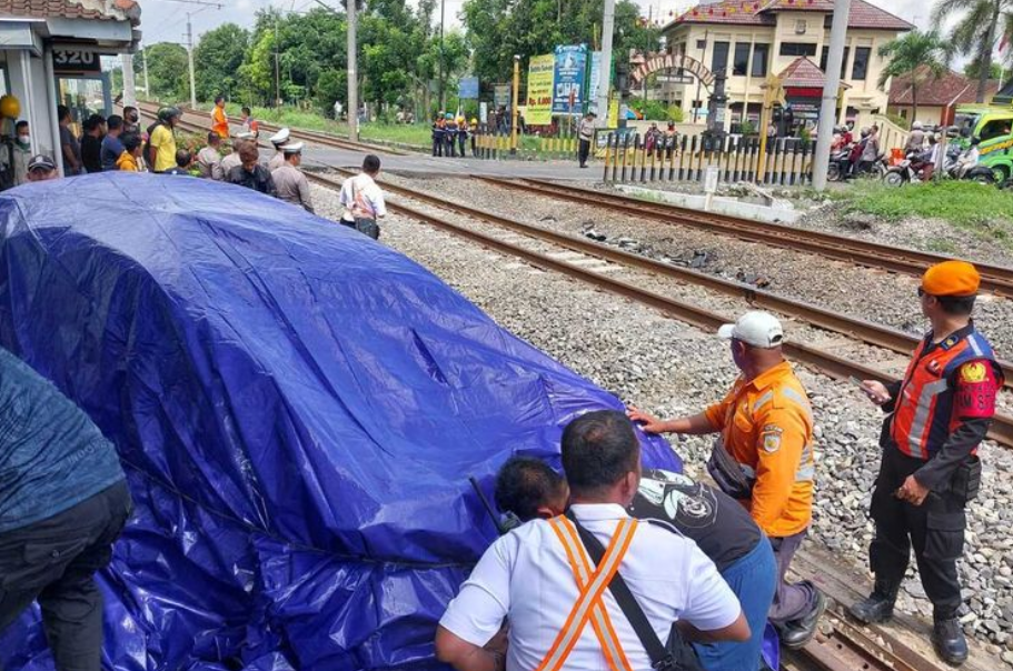 Petugas saat menutup mobil yang tertabrak kereta api di palang pintu Prambanan, Sleman.(KOMPAS.COM/YUSTINUS WIJAYA KUSUMA)
